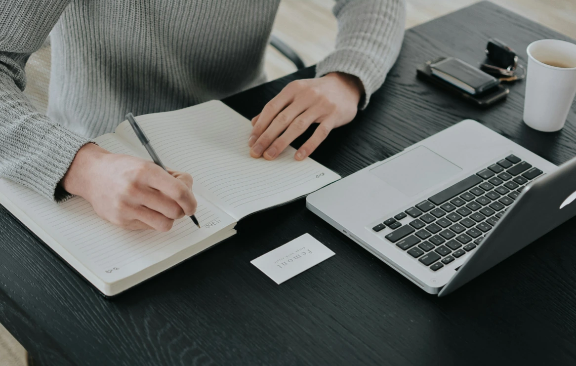 a person is writing something in a notebook